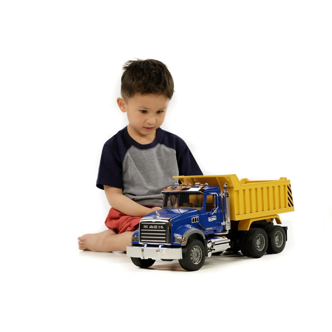 Child playing with a toy dump truck on a white background