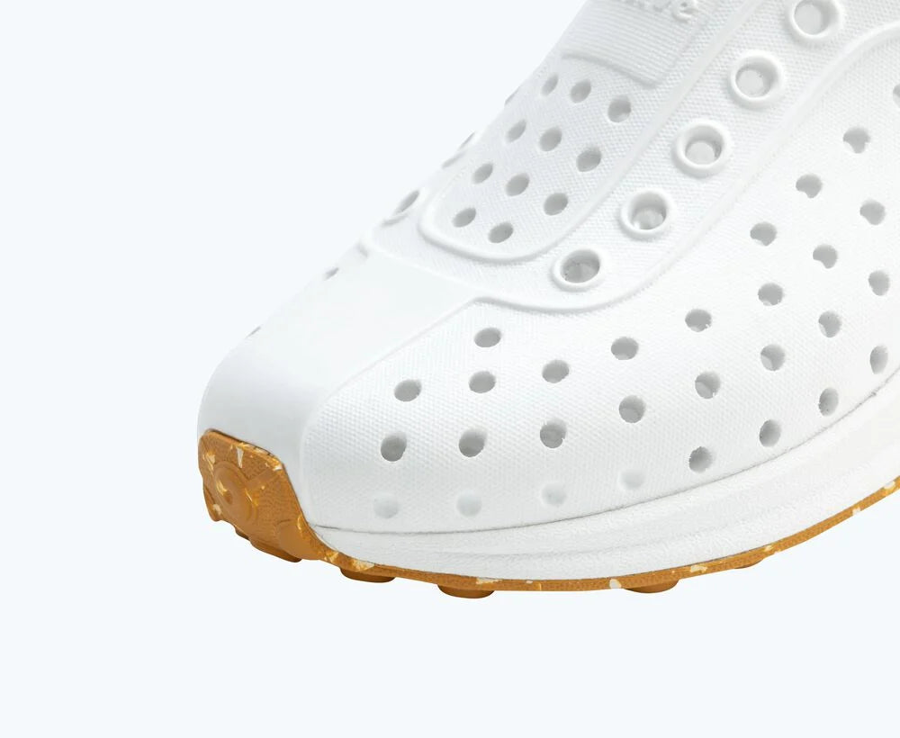 White shoe with brown sole on a white background