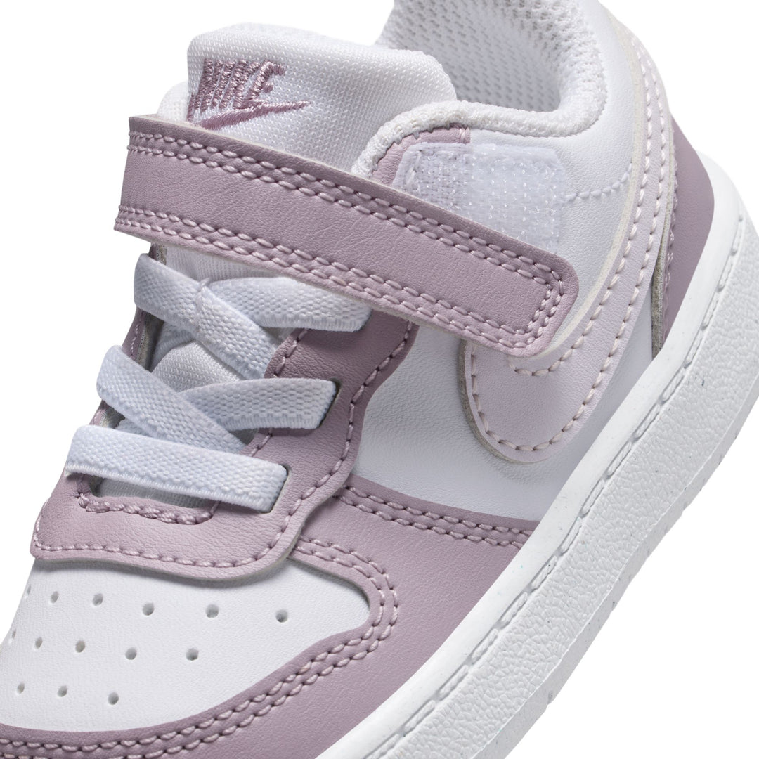 White and pink children's sneakers with Nike logo on a white background