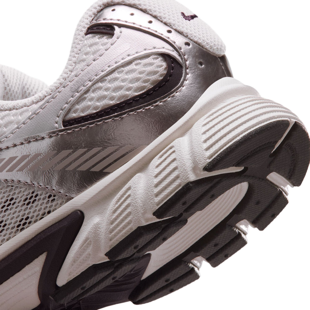 Close-up of a running shoe with tread pattern on a white background