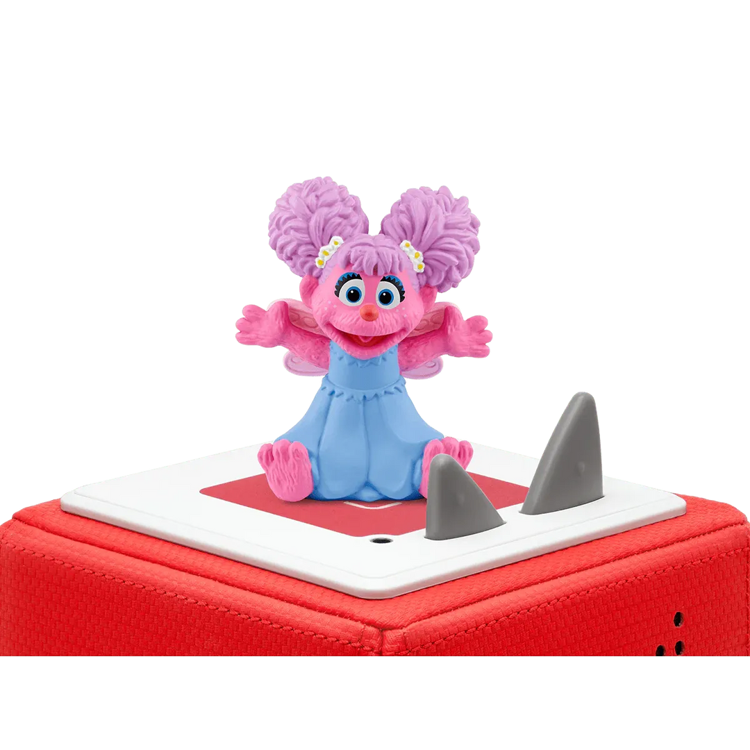 Pink character figurine on a red and white base with shark fins against a white background
