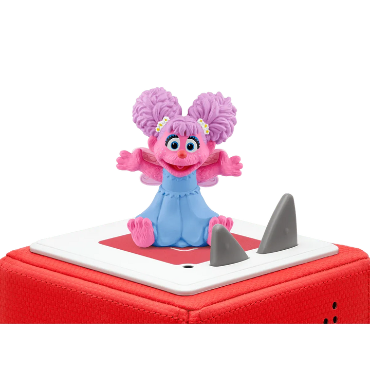 Pink character figurine on a red and white base with shark fins against a white background