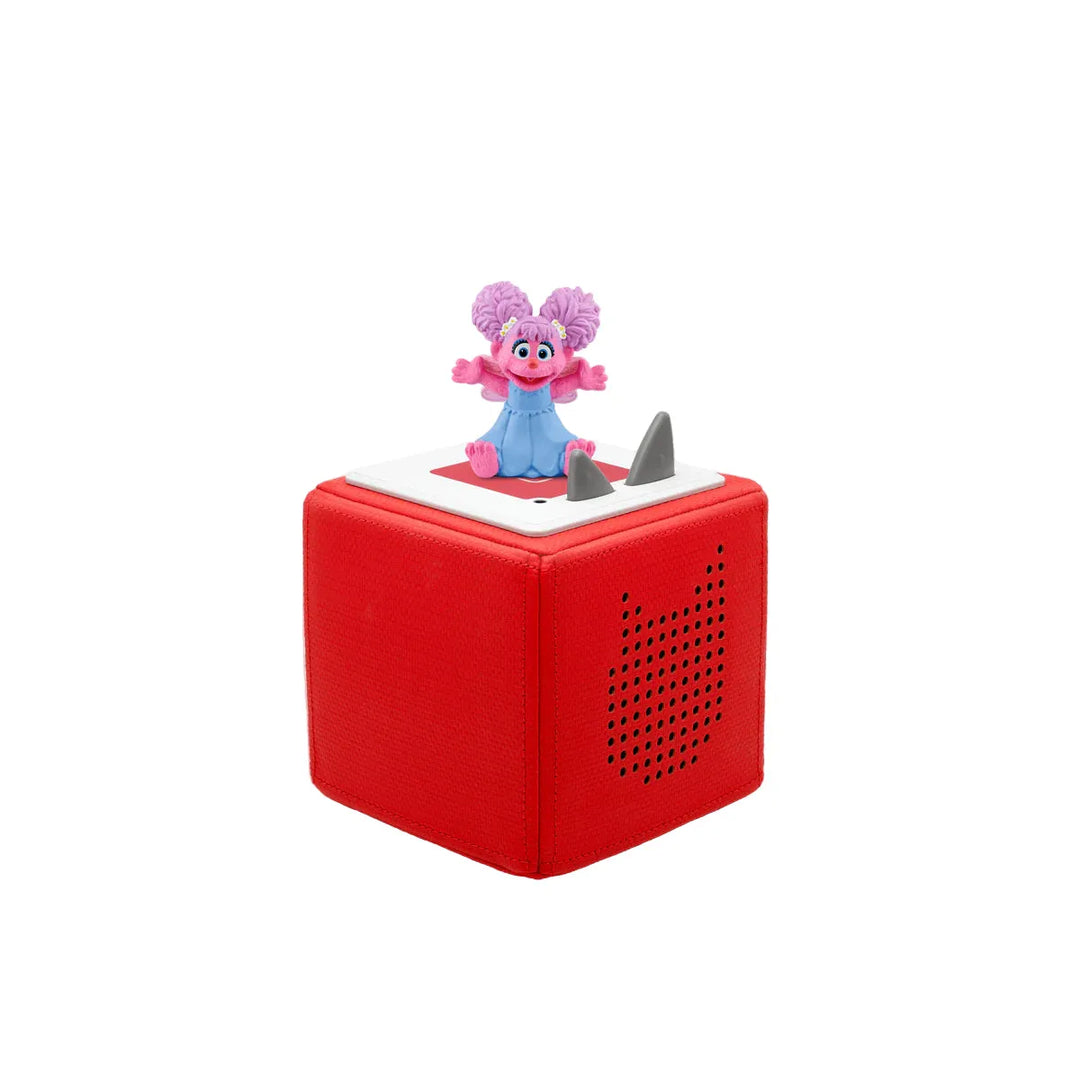 Red toy box with a purple and pink character on top against a white background