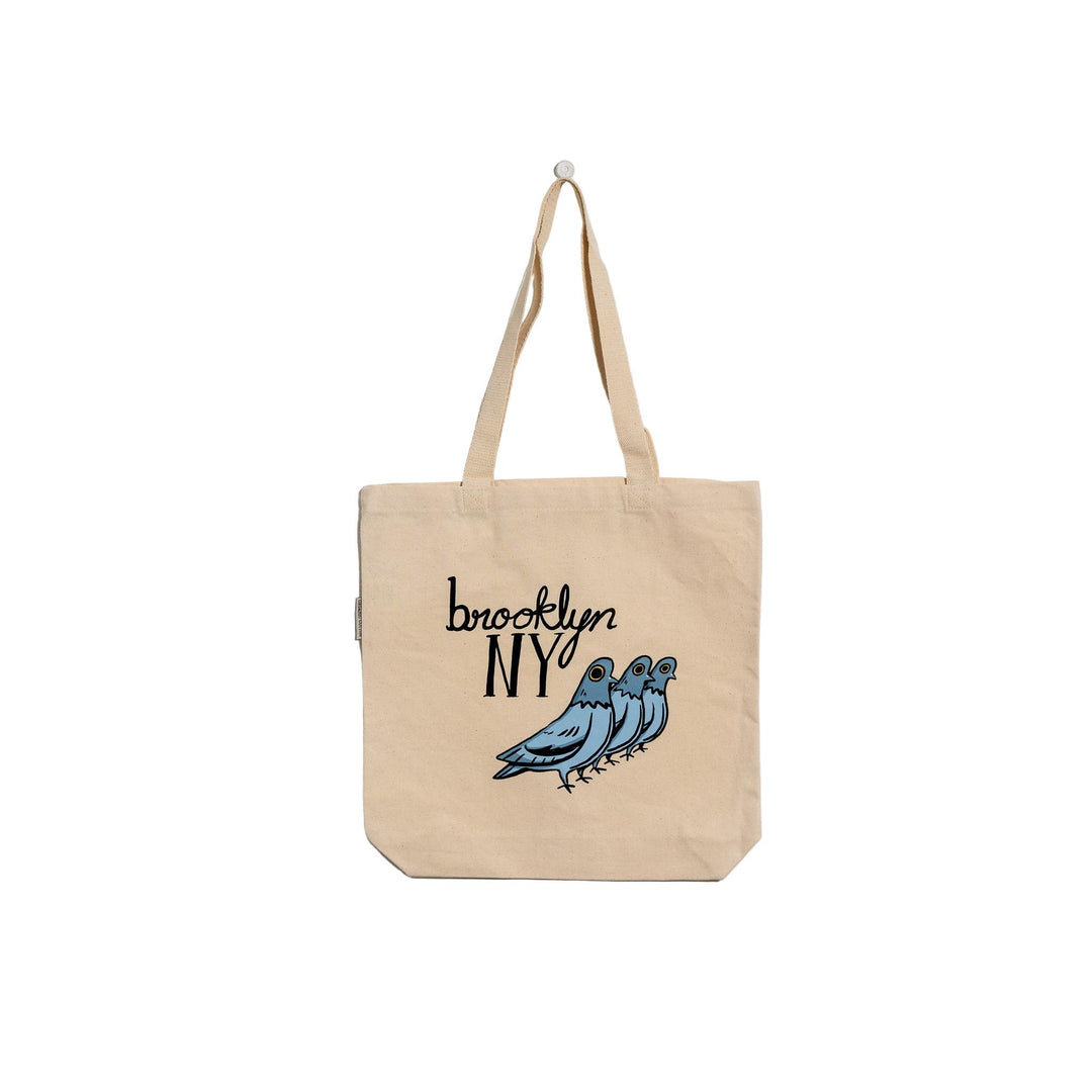 Beige tote bag with 'Brooklyn NY' and bird design on a textured white background
