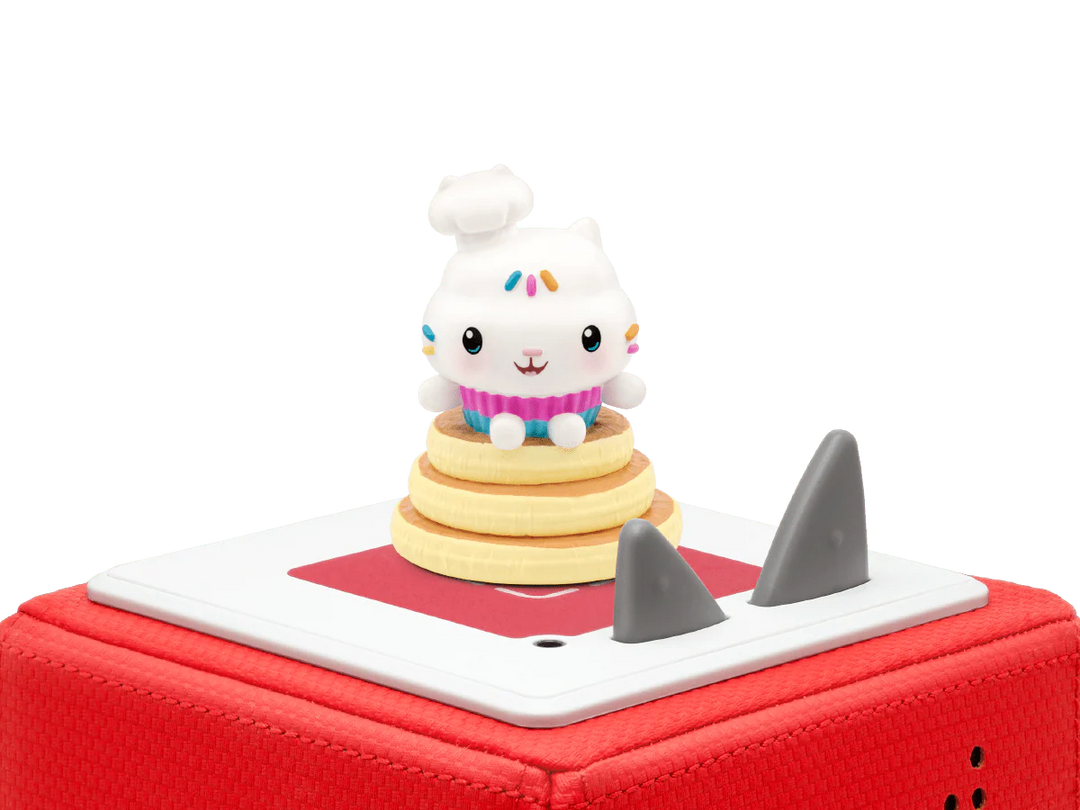 Toy figure of a character on a red toy boat with shark fin on a white background