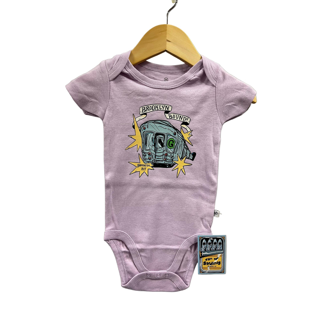 Purple baby onesie with graphic design on a hanger against a gray background