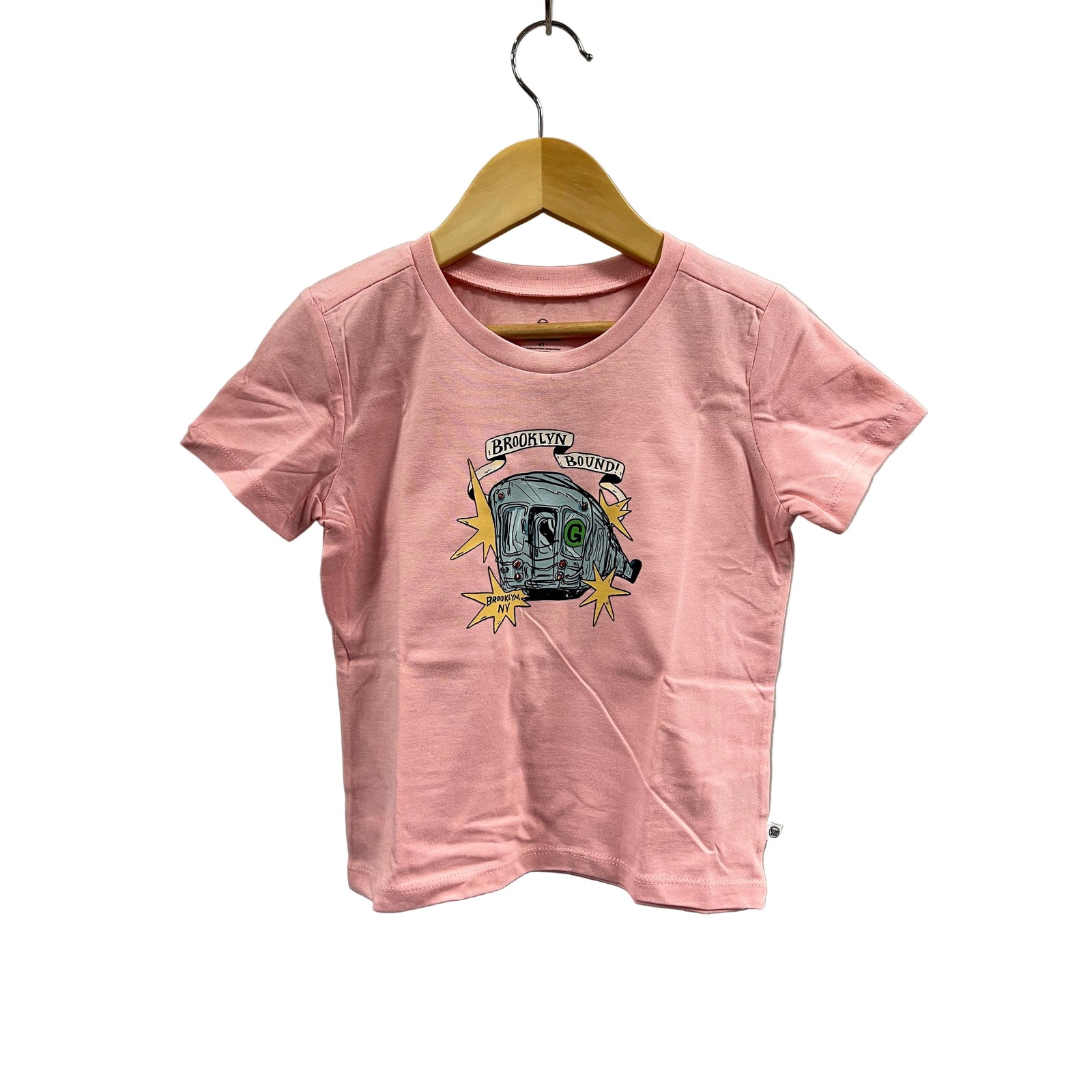 Pink t-shirt with graphic design on a hanger against a gray wall