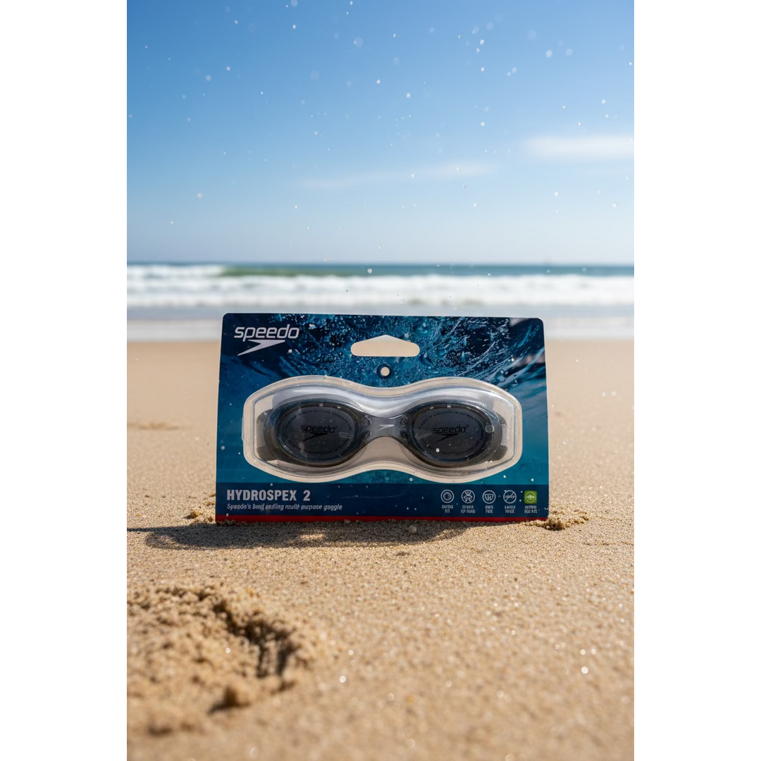 Speedo HydroDropeX 2 swim goggles in their original retail packaging, displayed on a countertop with a red tumbler and a VISA card in the background.