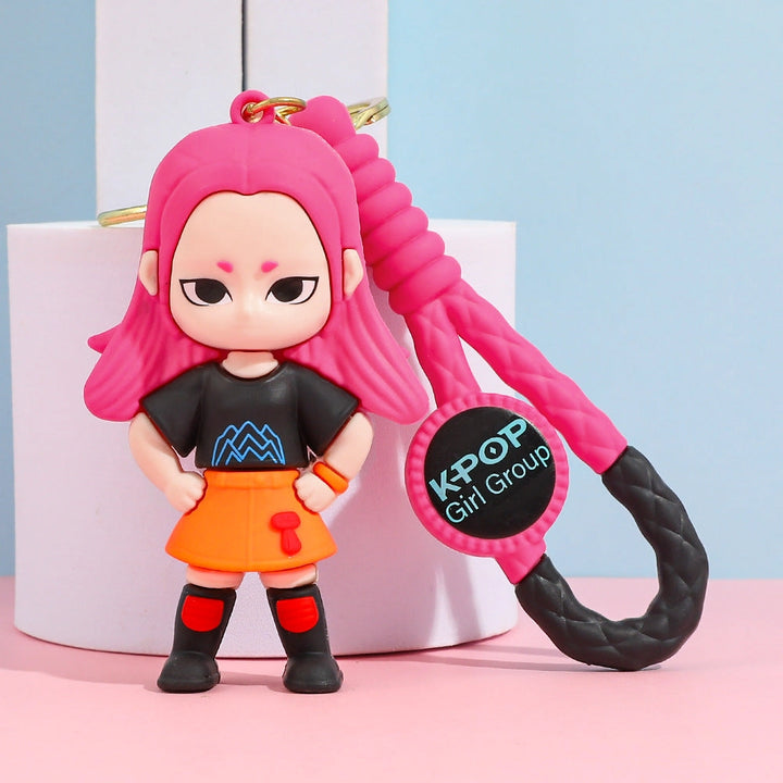 Keychain with a character wearing a black shirt and orange skirt, featuring pink hair and a 'K-POP Girl Group' tag.