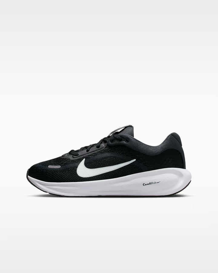 Black Nike running shoe with white sole on a white background