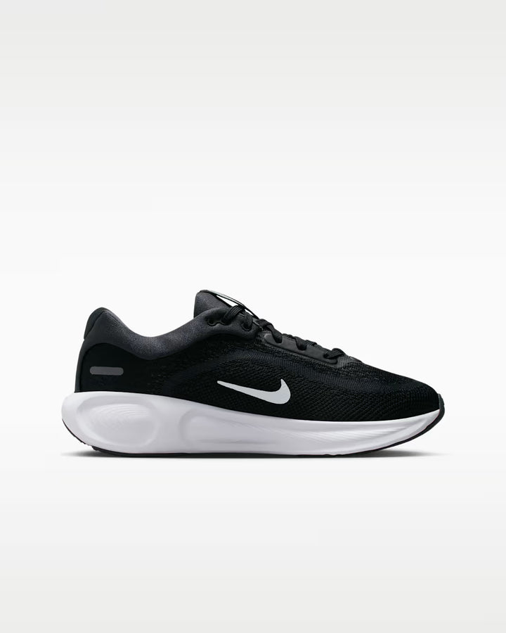 Black running shoe with white sole on a light gray background