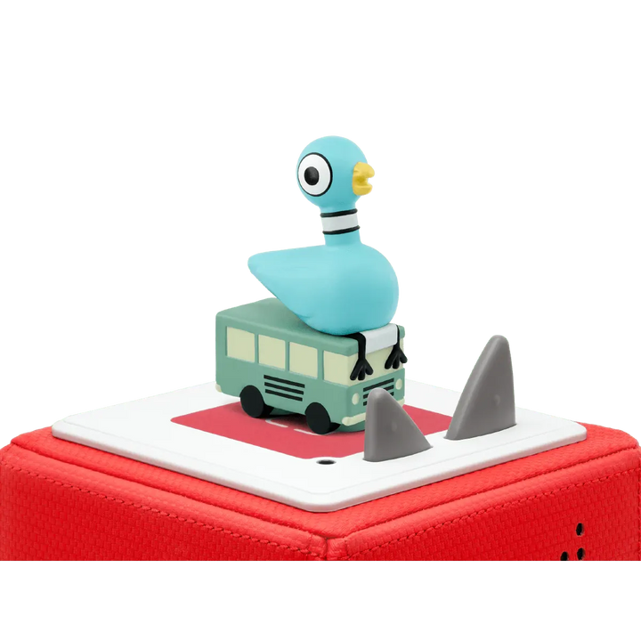 Toy figure of a blue character on a small bus with shark fins on a red base