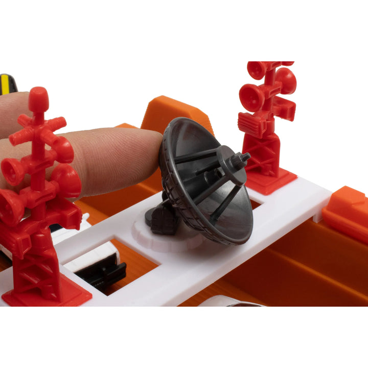 Close-up of a toy setup with red and orange structures and a black satellite dish.