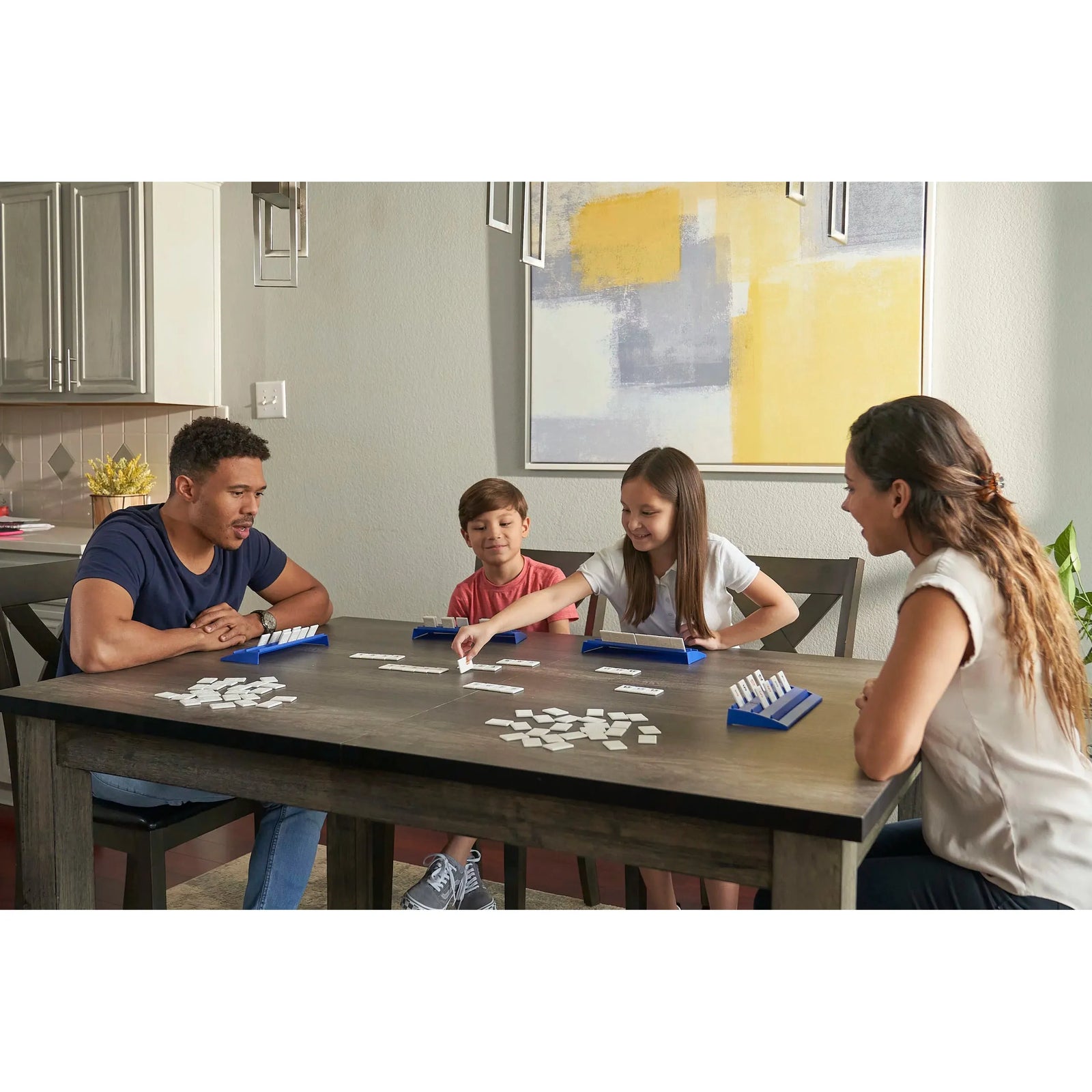 Family playing a board game together in a living room.