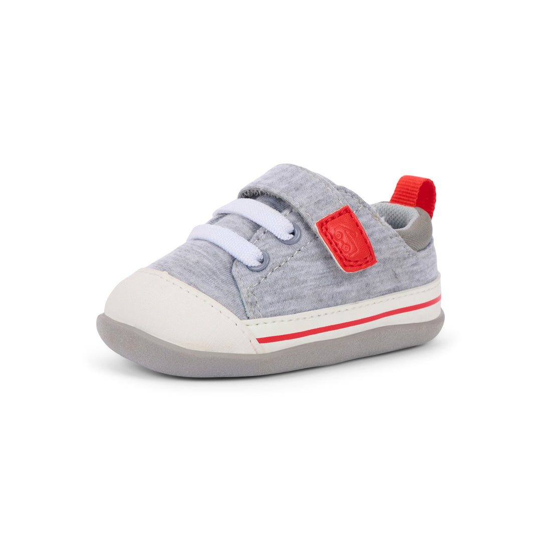 Gray baby shoe with red accents on a white background