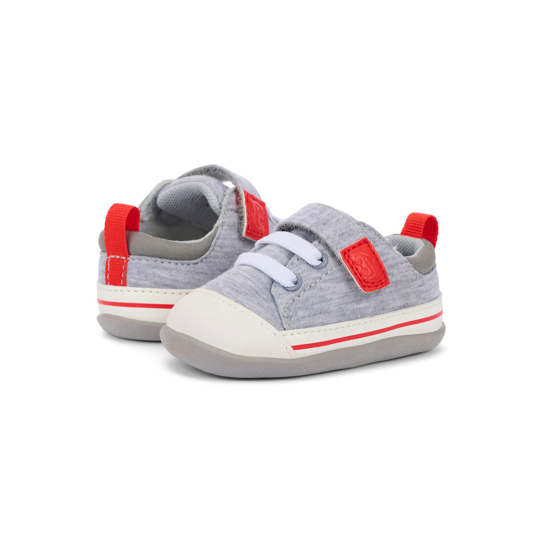 Gray children's sneakers with red accents on a white background