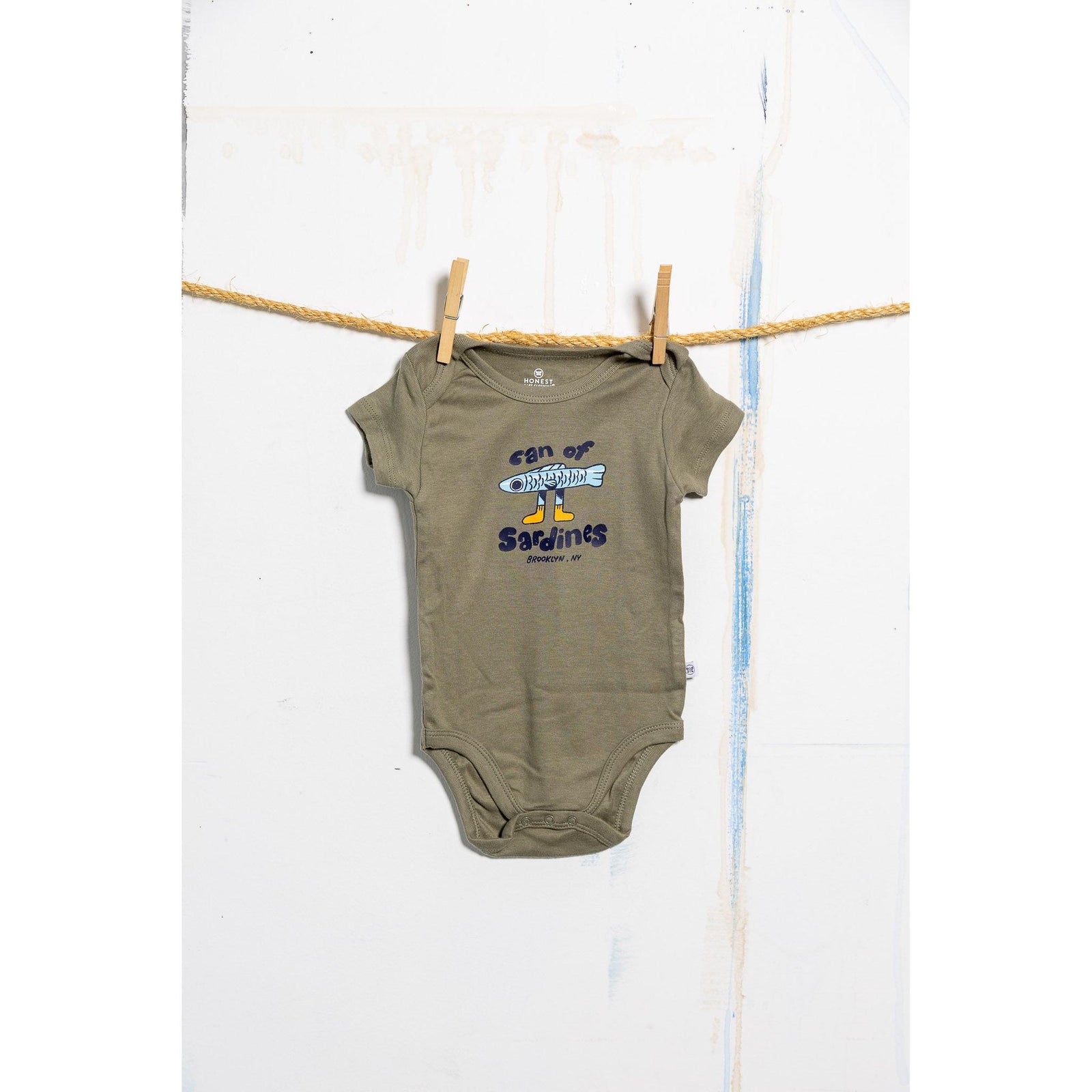 Green baby onesie with text and graphics on a white background