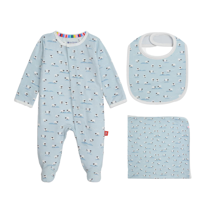 Baby onesie, bib, and blanket set with dog pattern on a light blue background