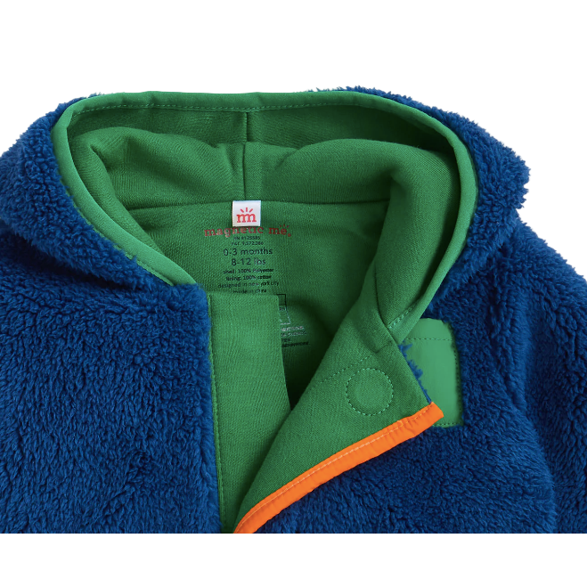 Close-up of a blue fleece jacket with green interior and orange trim, featuring a brand label.