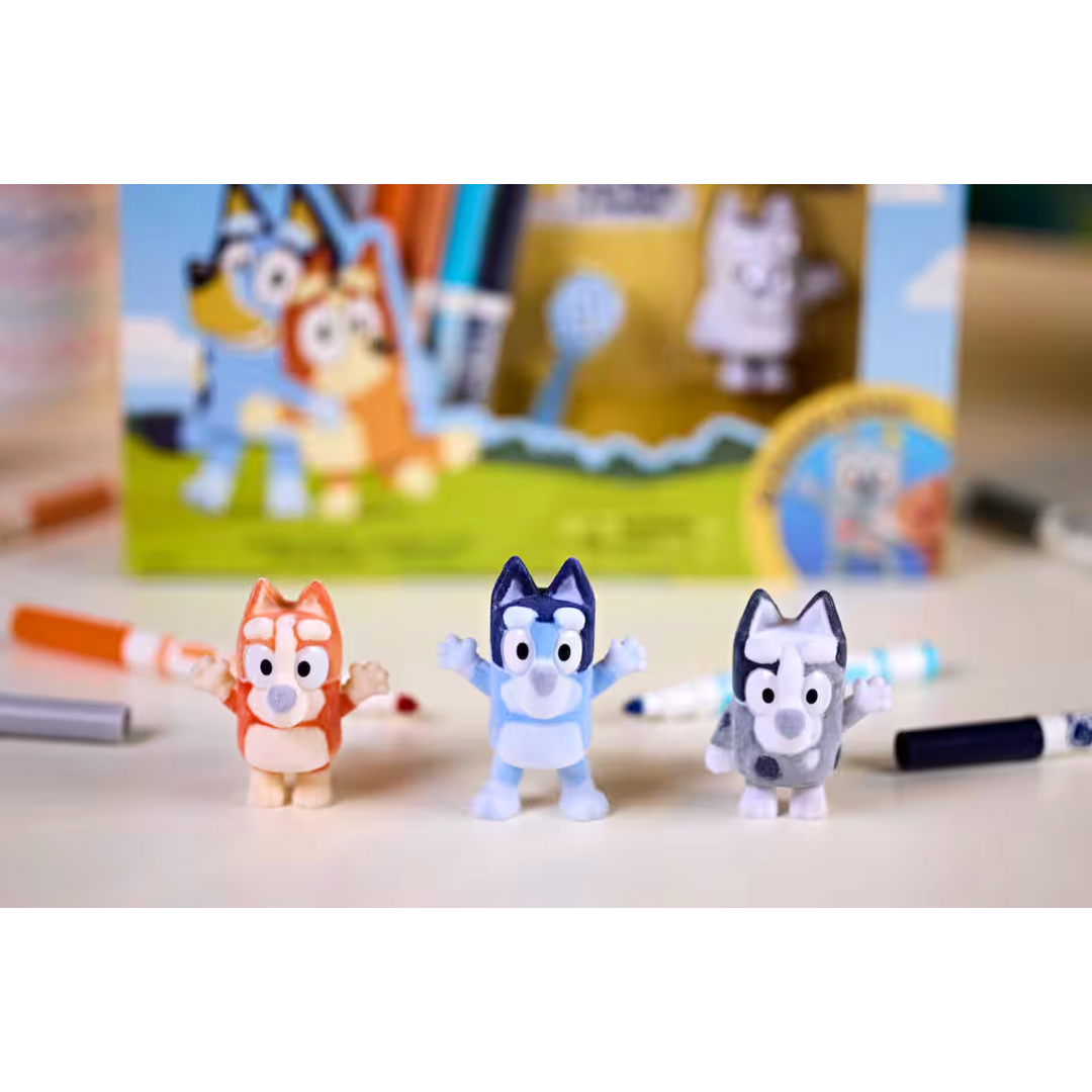 Three small figurines of cartoon characters on a table with a colorful background