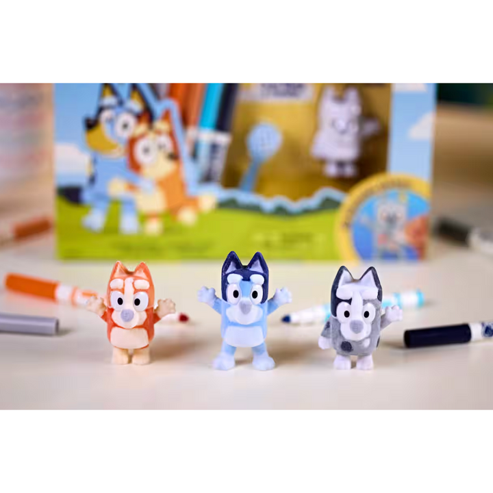 Three small figurines of cartoon characters on a table with a colorful background