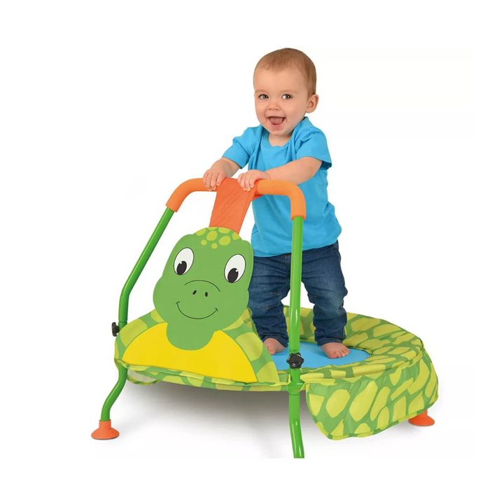 Child playing on a green turtle-shaped trampoline with a white background