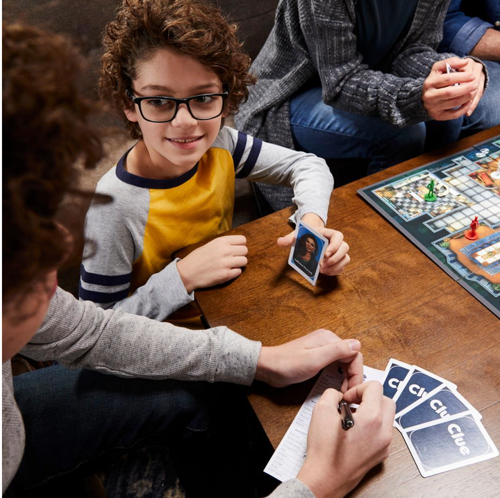 Children playing a board game with cards on a wooden table.