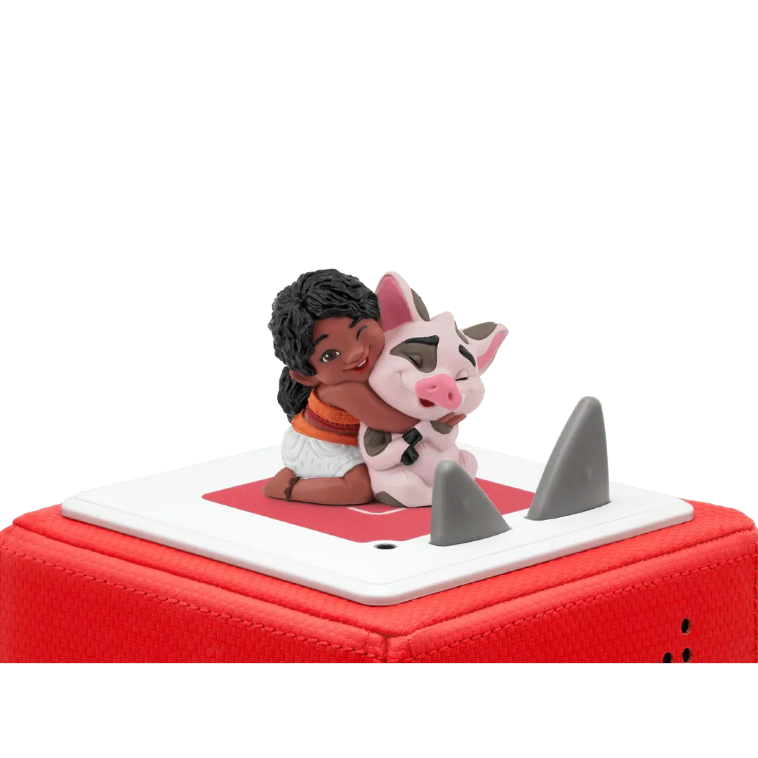Figurine of a girl and a cow on a red and white vehicle with shark fins.
