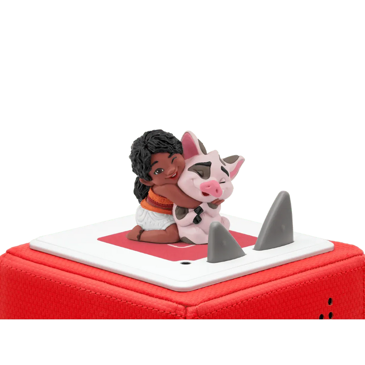 Figurine of a girl and a cow on a red and white vehicle with shark fins.