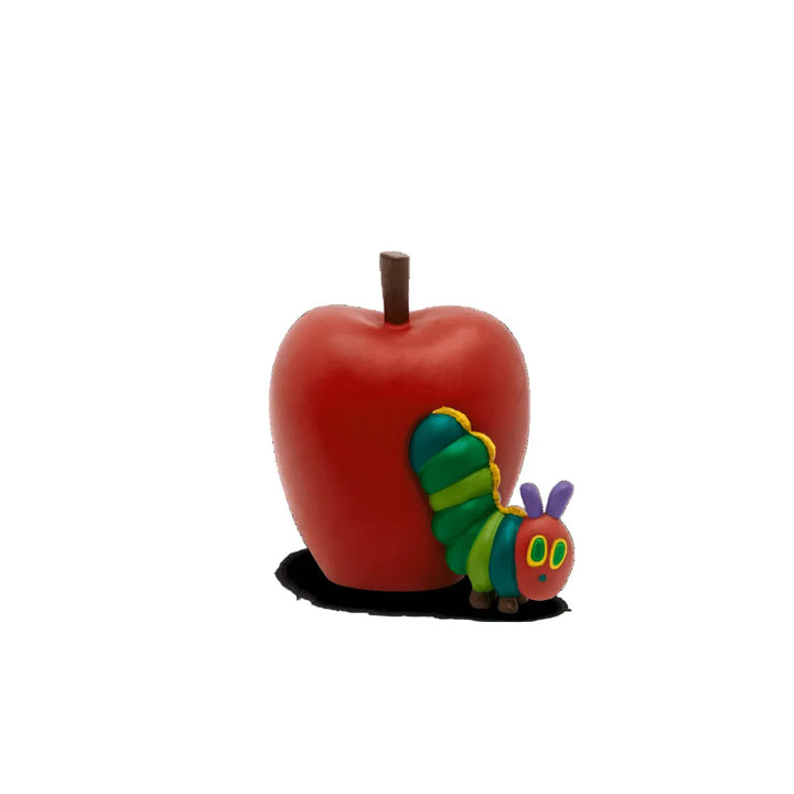 Red apple with a colorful caterpillar toy on a white background