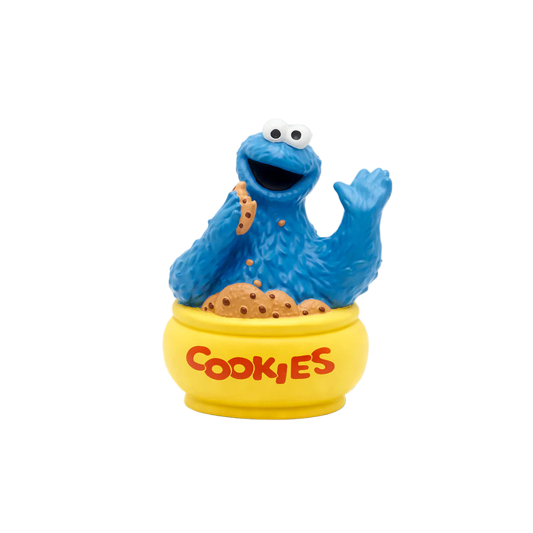 A plastic figure of Cookie Monster from Sesame Street sitting on a yellow base with the word 'COOKIES' on it, designed as an interactive toy.