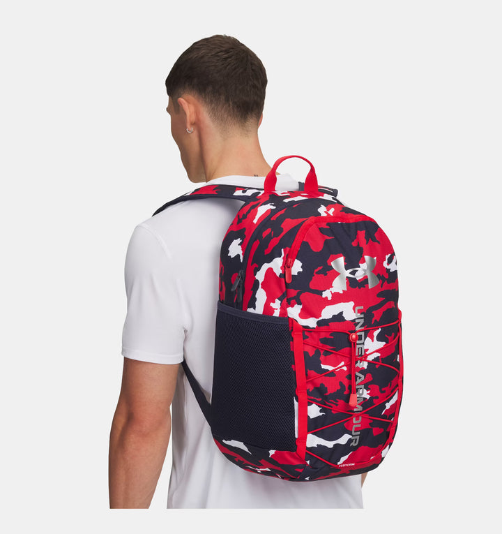 Person wearing a red and black patterned backpack on a white background