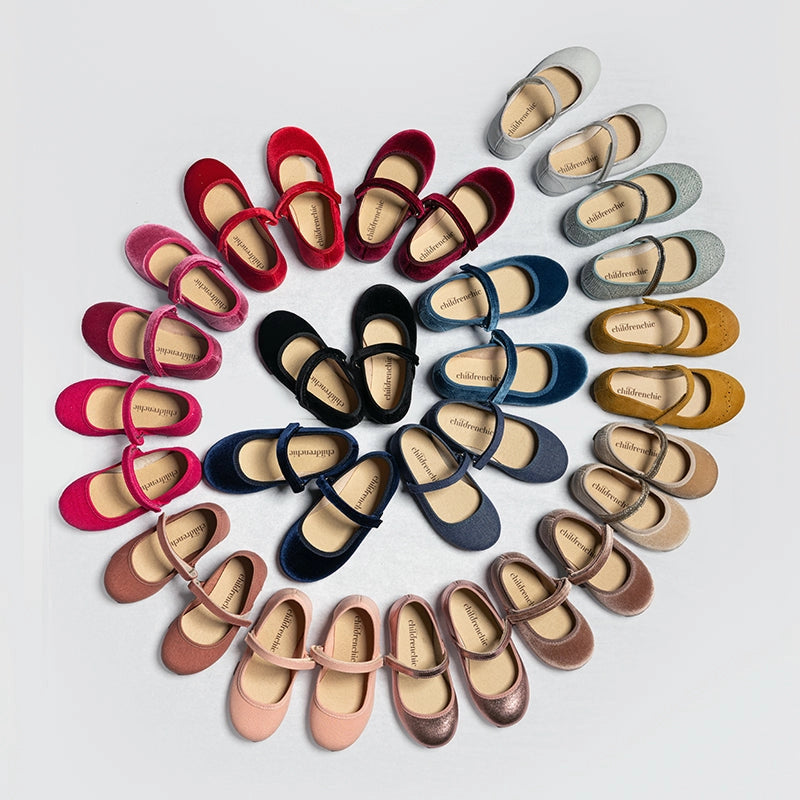 Colorful children's shoes arranged in a circular pattern on a light gray background