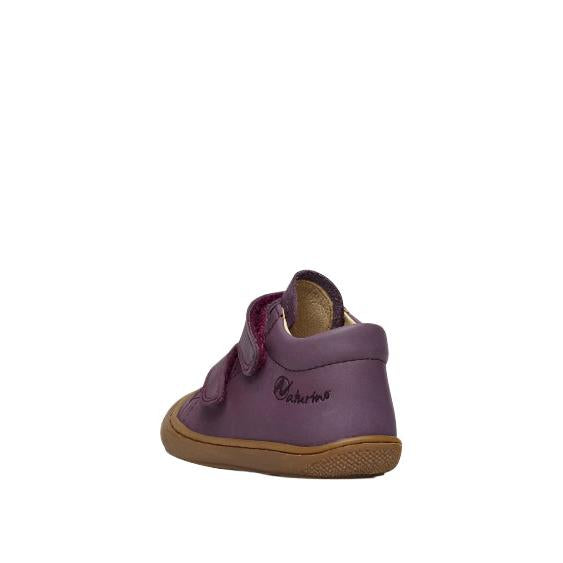 Purple children's shoe with brown sole on a white background