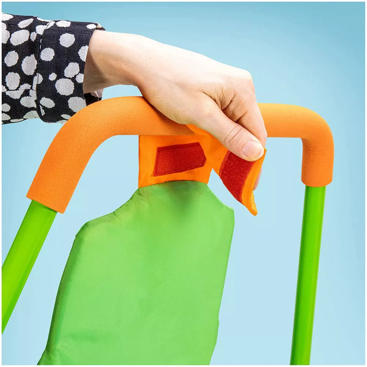 Green apron with orange handles held by a hand against a blue background