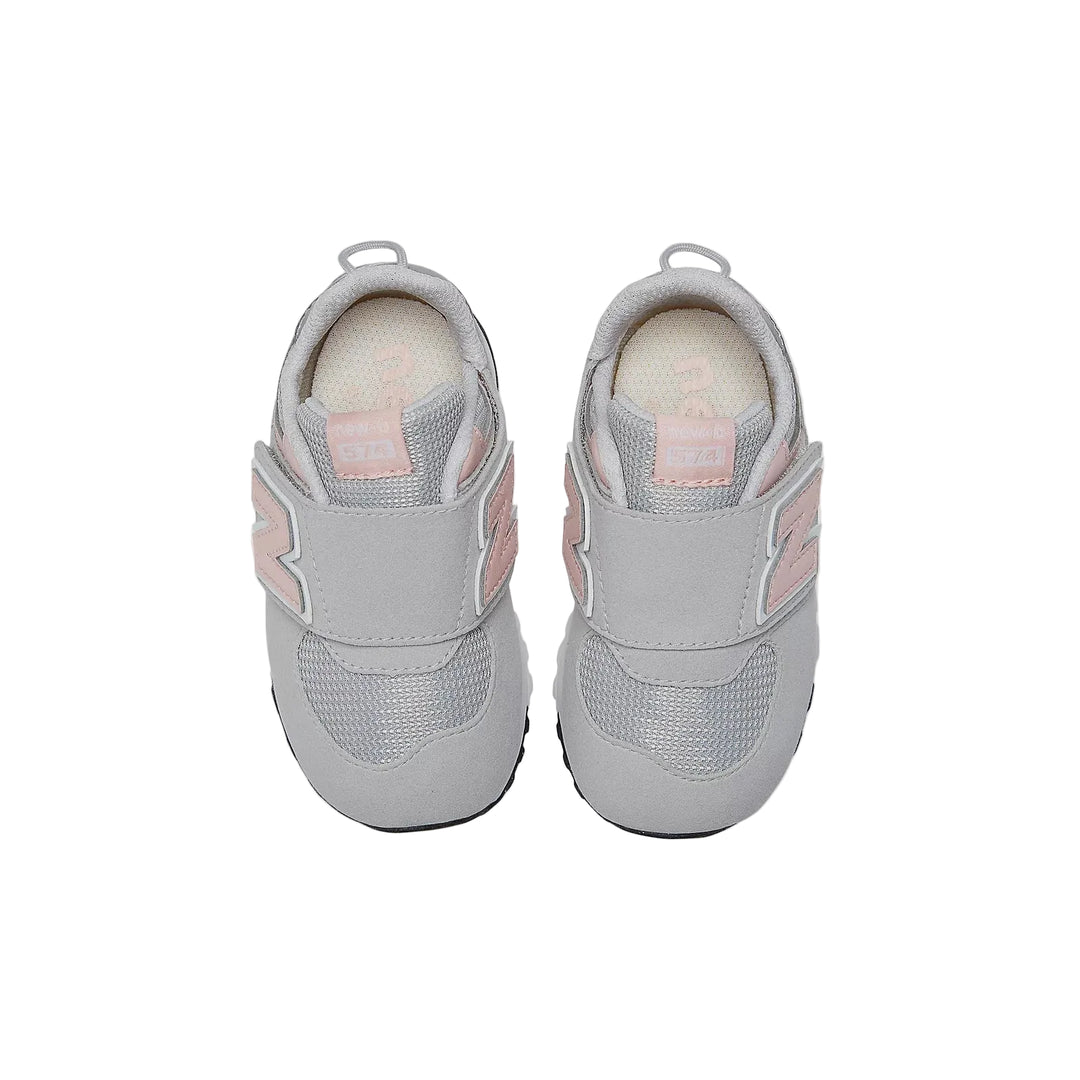 Pair of gray children's sneakers with pink accents on a white background