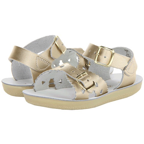 A pair of gold-colored children's sandals with heart-shaped cut-outs and buckled straps.