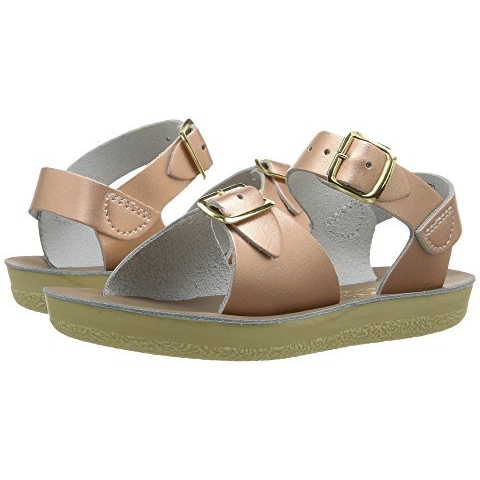 A pair of rose gold metallic sandals with two straps and adjustable ankle buckles, designed for toddlers or kids.