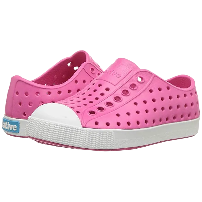 A pair of pink Native Jefferson Junior sandals for big kids with a white sole.