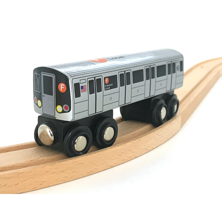 A wooden toy train representing a New York City Subway vehicle, painted in gray with colorful detail markings, riding on a wooden railway track.