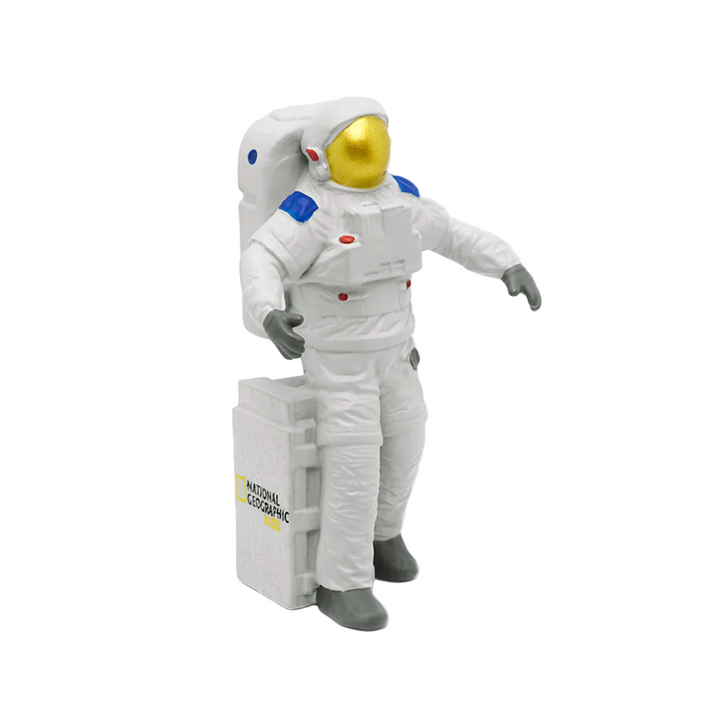 A Tonies astronaut figure in a white space suit with a yellow and blue emblem, standing next to a space shuttle figurine.